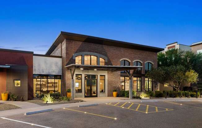 A modern building with a parking lot in front.