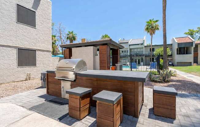 Community outdoor kitchen at Sono Tempe Apartments featuring built-in grills and seating in Tempe, AZ.