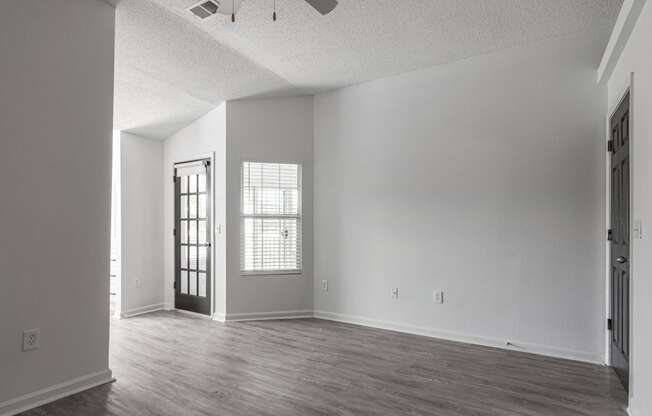 an empty living room with white walls and wood floors