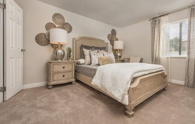 a bedroom with a bed and lamps and a window at Lodge of Overland Park Apartments, Overland Park , KS 66212