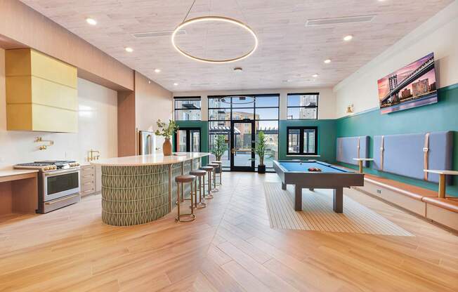 A room with a pool table and a bar area.