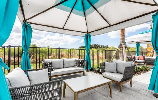 furnished patio area with seating and canopy in daytime