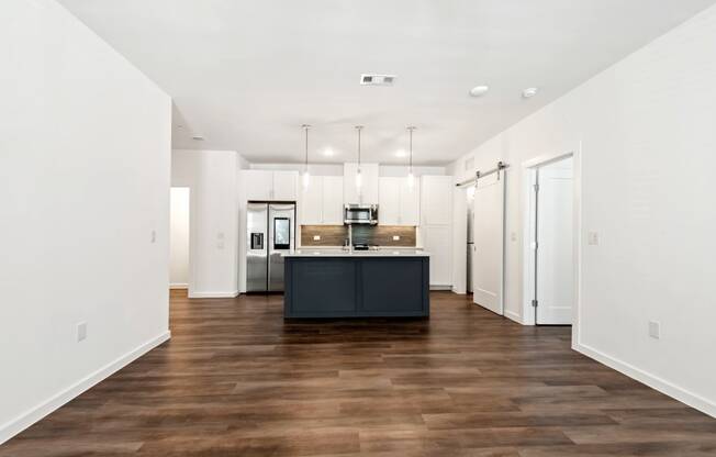 a kitchen with white walls and a black island in the middle of it