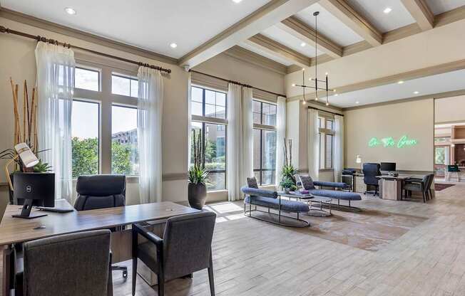 an office with a desk and chairs and large windows