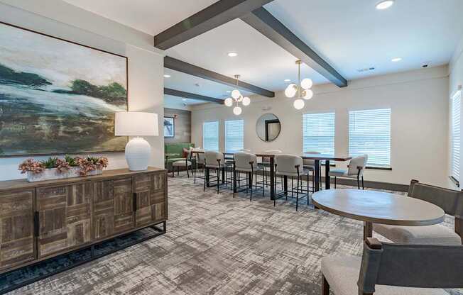 a dining room with tables and chairs and a large painting on the wall