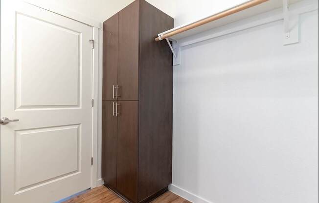 A brown wardrobe is in a white room at Riverplace Apartment Homes, Independence