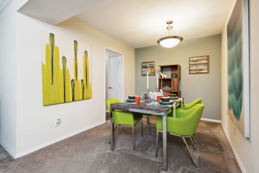 a dining room with a table and chairs and a painting on the wall at Lake Johnson Mews, Raleigh, 27606