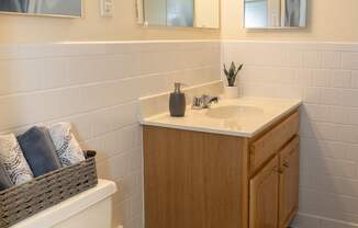 A bathroom with a toilet, sink, and mirror.