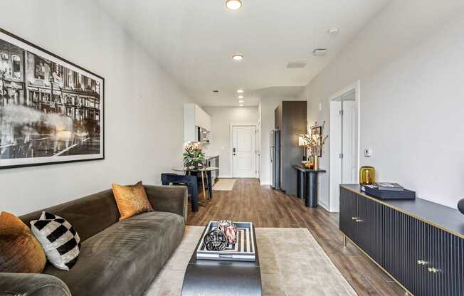 A living room with a brown couch and a coffee table.