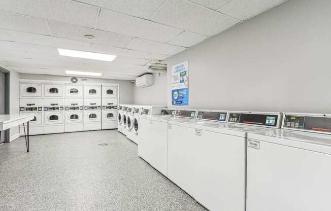 A laundry room with washing machines and a table.