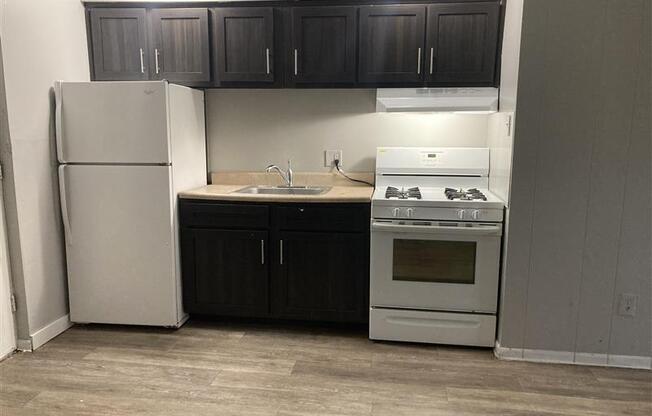 A kitchen with a white refrigerator and a white stove top oven.