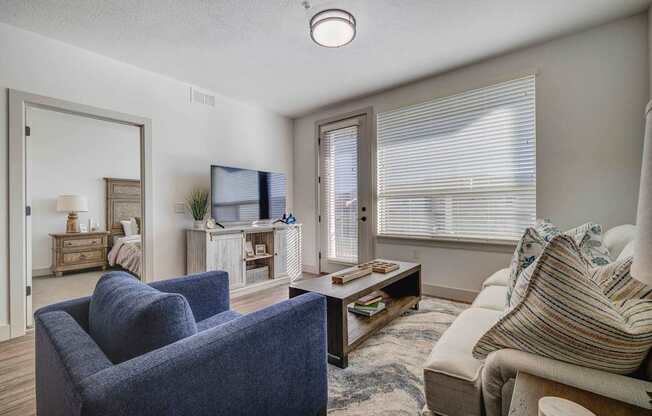 A living room with a blue chair and a white couch.