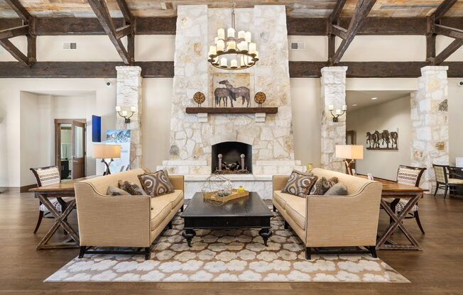 living room with couches and a table and a fireplace at Lakeline East Apartments, Texas