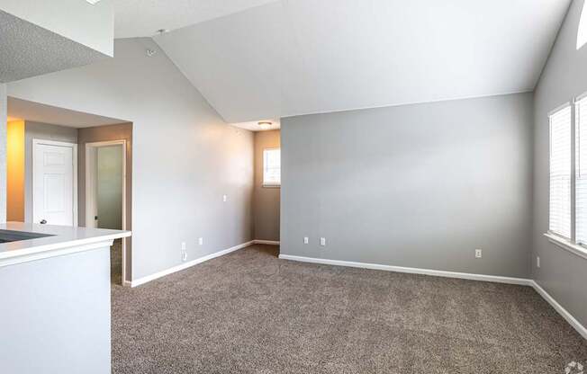 A spacious room with carpeted floor and white walls.
