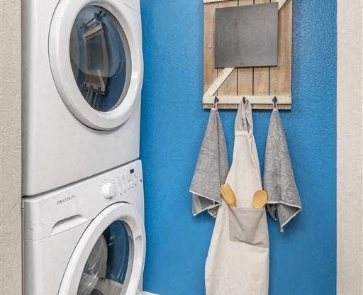 A washing machine is placed next to a dryer in a laundry room.