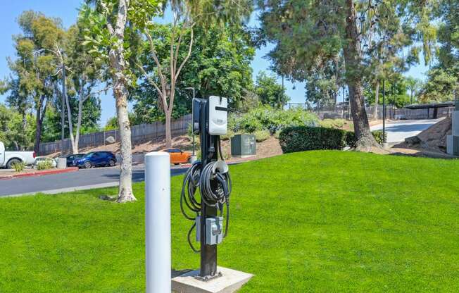 an electric vehicle charging station on the grass in a parking lot