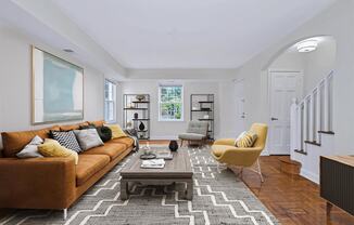 a living room with a couch and a coffee table    and a staircase