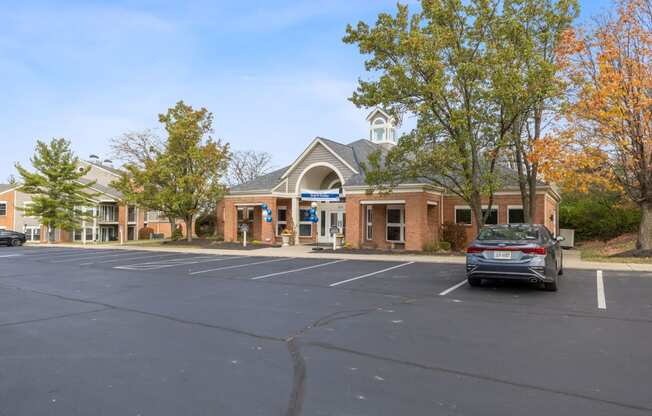 an empty parking lot in front of a brick building with a car parked in front