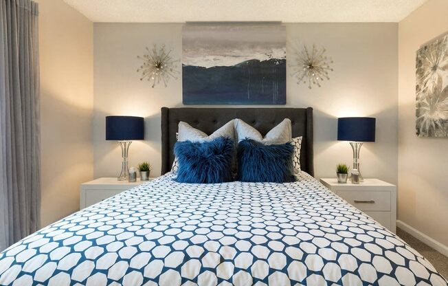 a blue and white bed in a bedroom with neutral walls