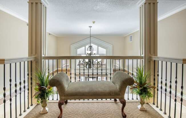 a large balcony with a couch and two potted plants