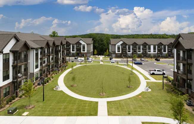 an aerial view of an oval lawn in front of apartment buildings