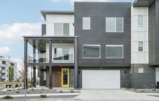 A modern two story house with a yellow door.