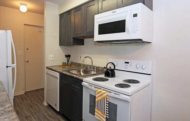 a kitchen with white appliances and a sink and a white microwave