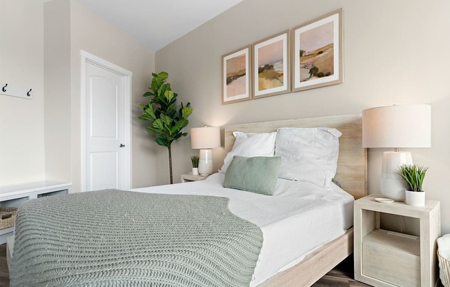 a bedroom with a bed and three paintings on the wall