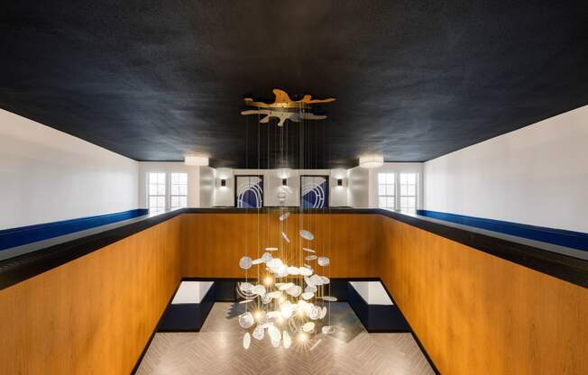 Glass chandelier hanging from a navy blue ceiling at Elme Alexandria, Virginia, 22304