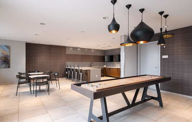 a communal table in a room with a kitchen and dining area