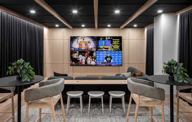 A modern living room with a large TV screen and comfortable seating.