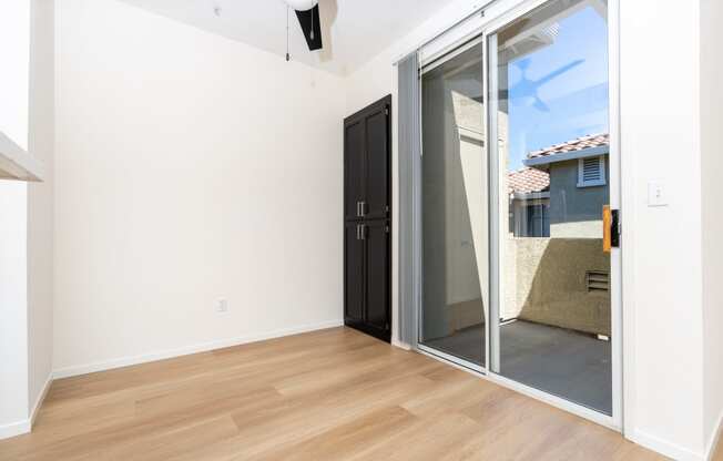 an empty living room with a sliding glass door to a patio