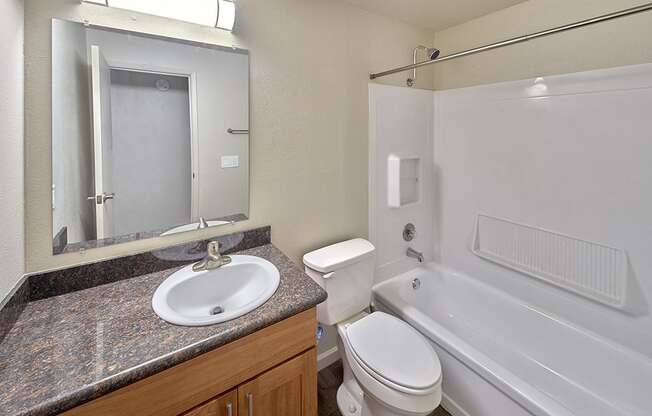 Full bathroom with light brown cabinets and light grey countertops.at Park View Apartments, Washington