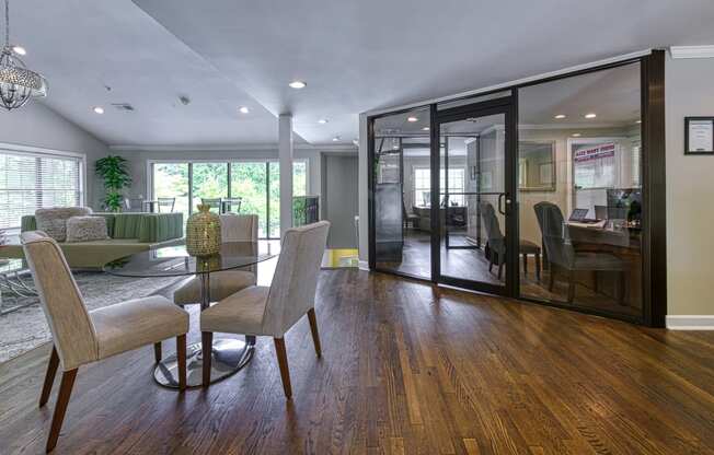 a dining room and living room with a glass table and chairs