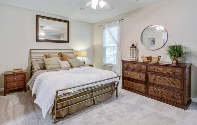 Furnished master bedroom with ceiling fan and walk-in closet at Westmont Commons apartments for rent