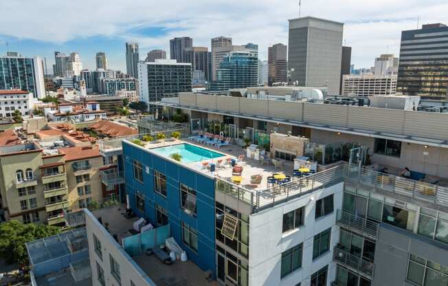 a pool on the roof of a building with a city in the background