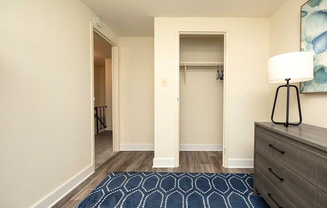 A hallway with a rug and a lamp on the side table.