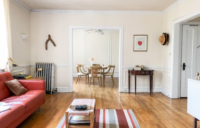 a living room with a red couch and a table and chairs