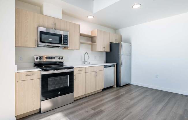 A kitchen with a stove, oven, microwave, and refrigerator.