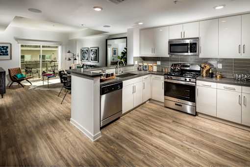 A modern kitchen with a wooden floor and stainless steel appliances.
