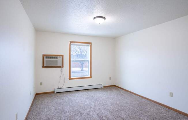 A room with a window and a picture on the wall. Fargo, ND Park Place Apartments