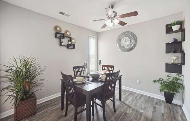 a dining room with a table and chairs and a ceiling fan