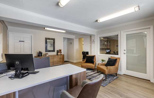 a living room with a desk and chairs