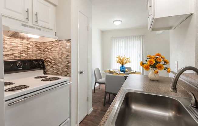 This is a photo of a virtually staged kitchen looking into dining area in the 640 square foot 1 bedroom apartment at The Summit at Midtown Apartments in Dallas, TX.