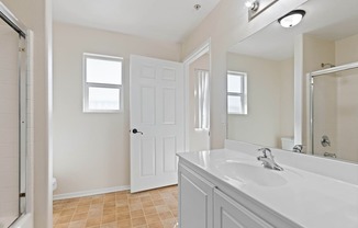 A bathroom with a white sink and a white door.