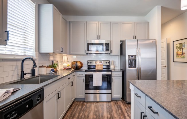 a kitchen with white cabinets and stainless steel appliances