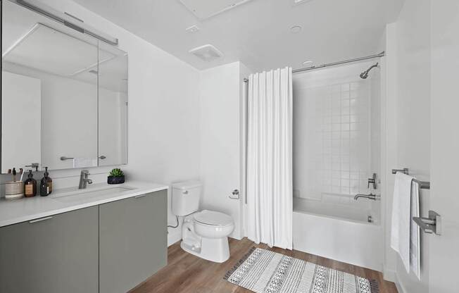 A white bathroom with a toilet, sink, and bathtub.