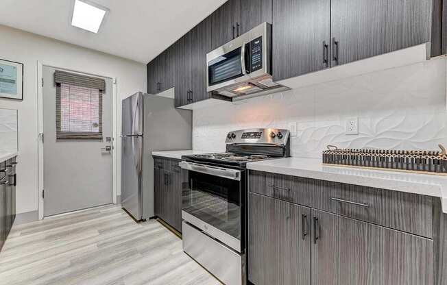 A modern kitchen with a stainless steel refrigerator and oven.