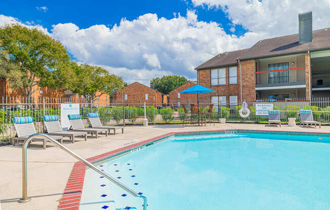 A pool with a red and blue border and a metal railing.