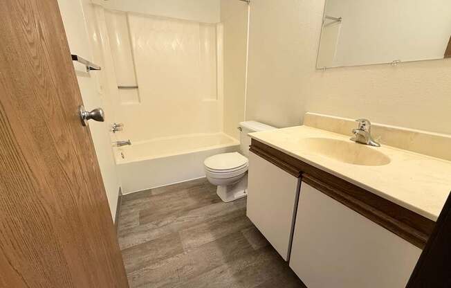 A bathroom with a toilet, sink, and bathtub.